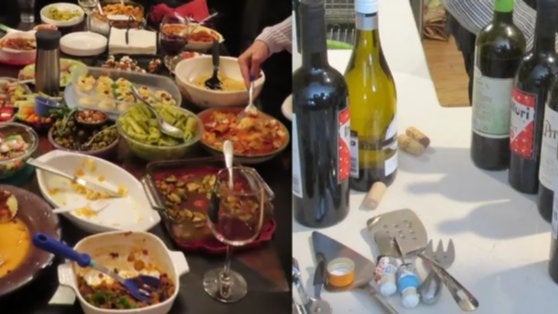 GVL A table filled with various dishes, including vegetables and casseroles, with a person serving food. Nearby, there is a counter with bottles of red and white wine, corks, a bottle opener, and small condiments.