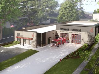 GVL A modern new fire station in Greenville features a red fire truck parked in front of the open garage bay. Surrounded by trees, grass, and a paved driveway, the building displays the number 4 prominently on the station.